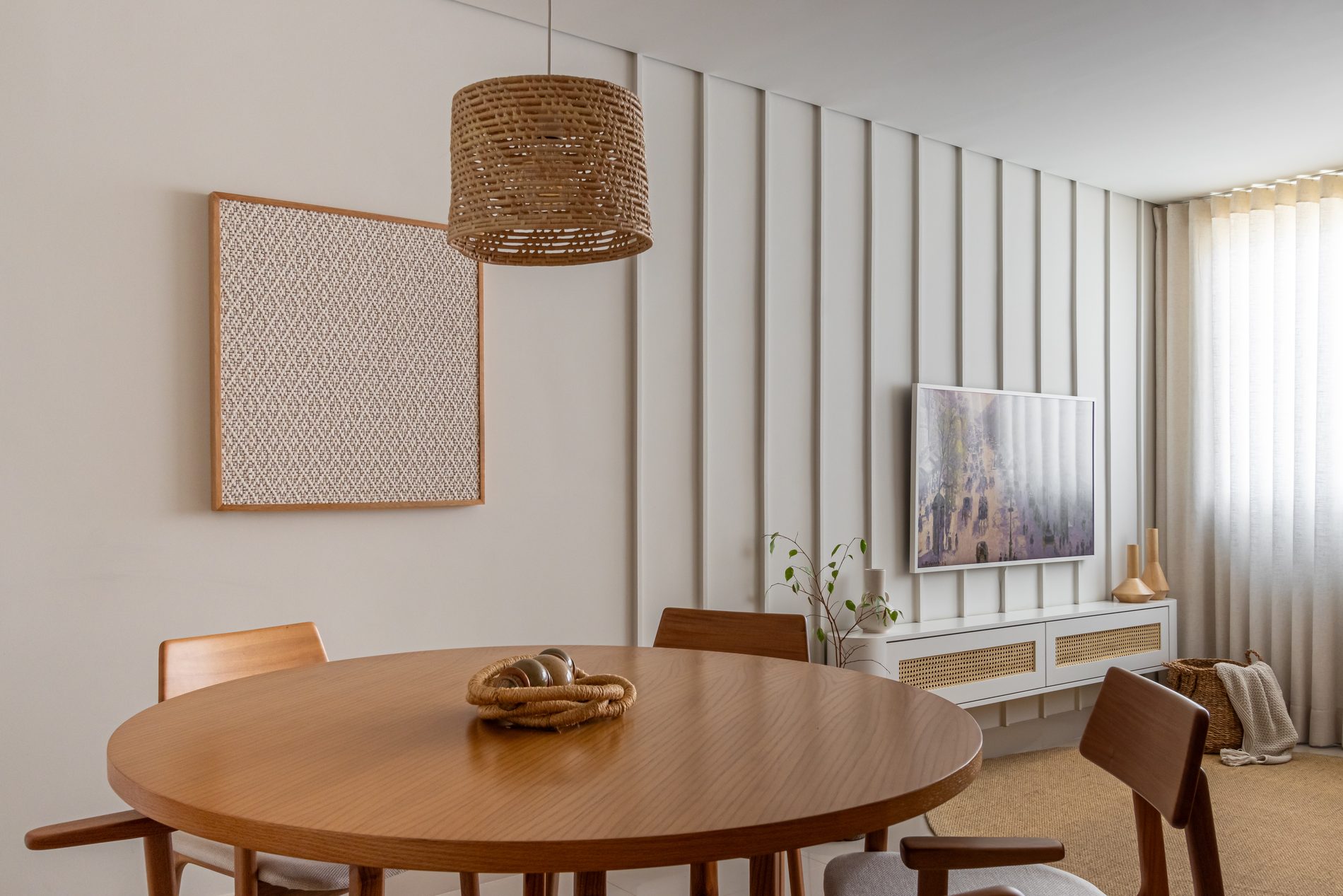 Sala de jantar com mesa redonda e painel claro