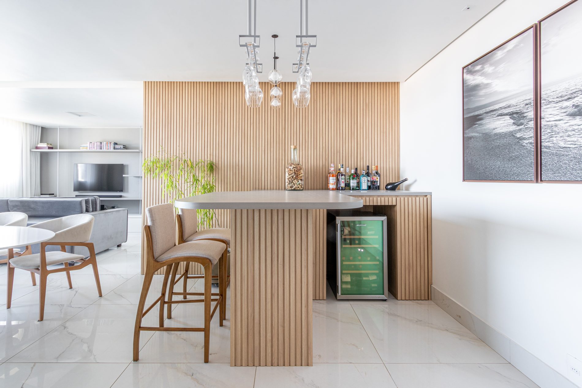 Cozinha integrada com bancada de madeira e adega